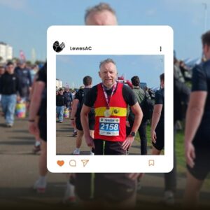 Lewes AC's Geoff Watson celebrates crossing the finish line of the 2026 Hastings Half Marathon with a medal in hand.